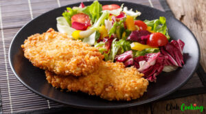 panko crispy chicken breast with salad on black plate. Healthy dinner ideas