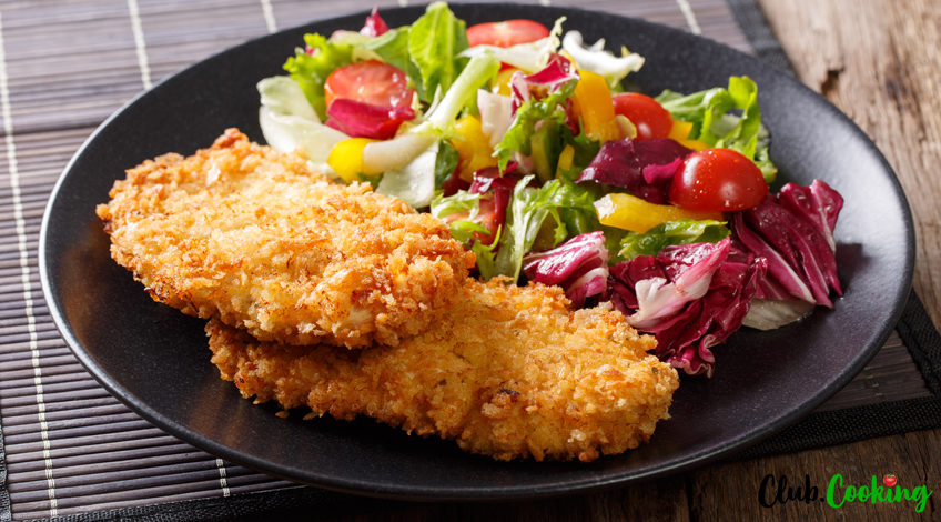 panko crispy chicken breast with salad on black
