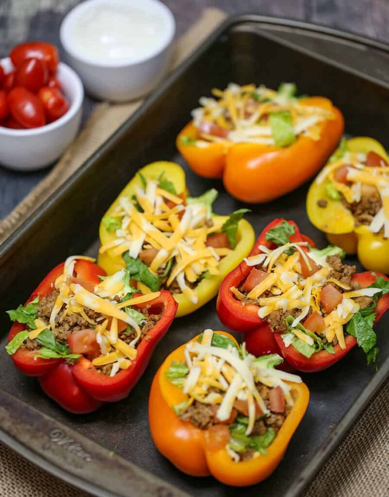 taco stuffed peppers in a baking try topped with cheese