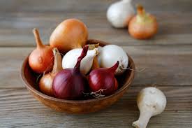 A variety of onions in a bowl.