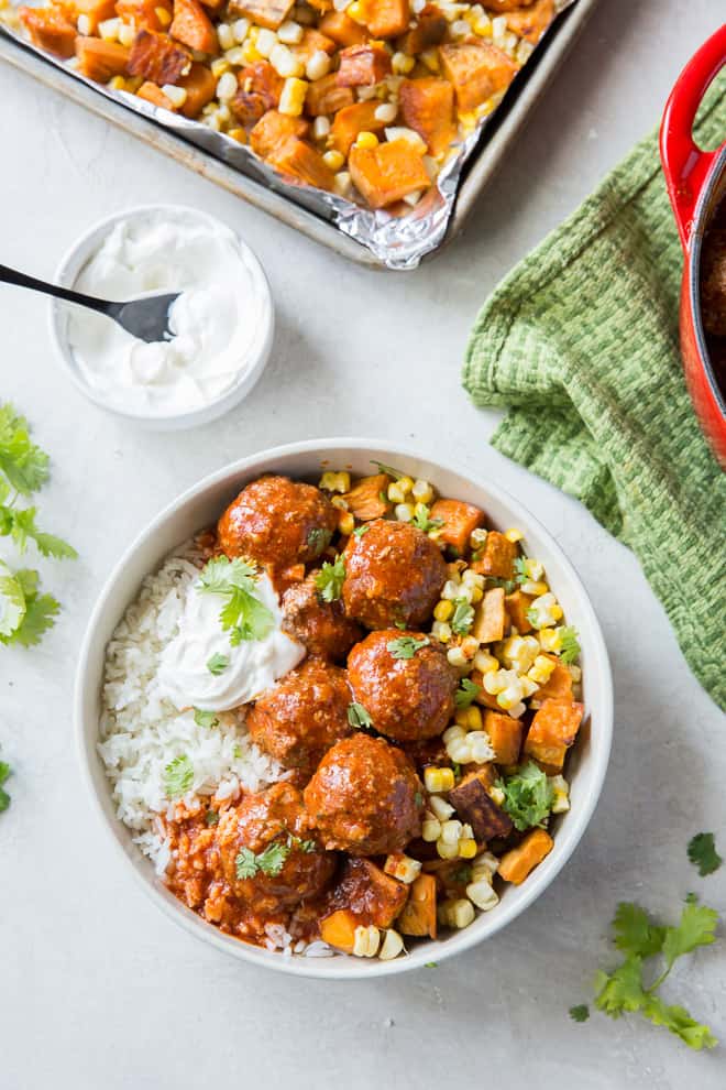 Homemade tex mex meatballs served with rice and roasted vegetables.