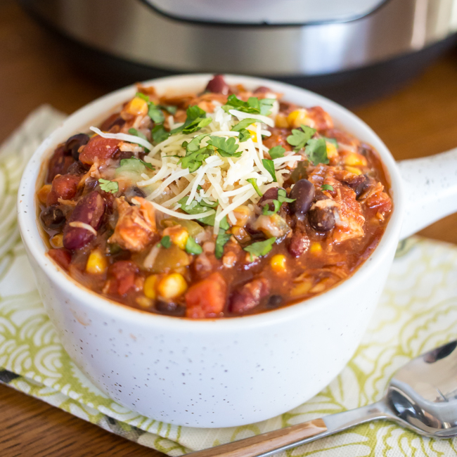 Easy homemade instant pot turkey chili recipe ready in 40 minutes, topped with cilantro and grated cheese.