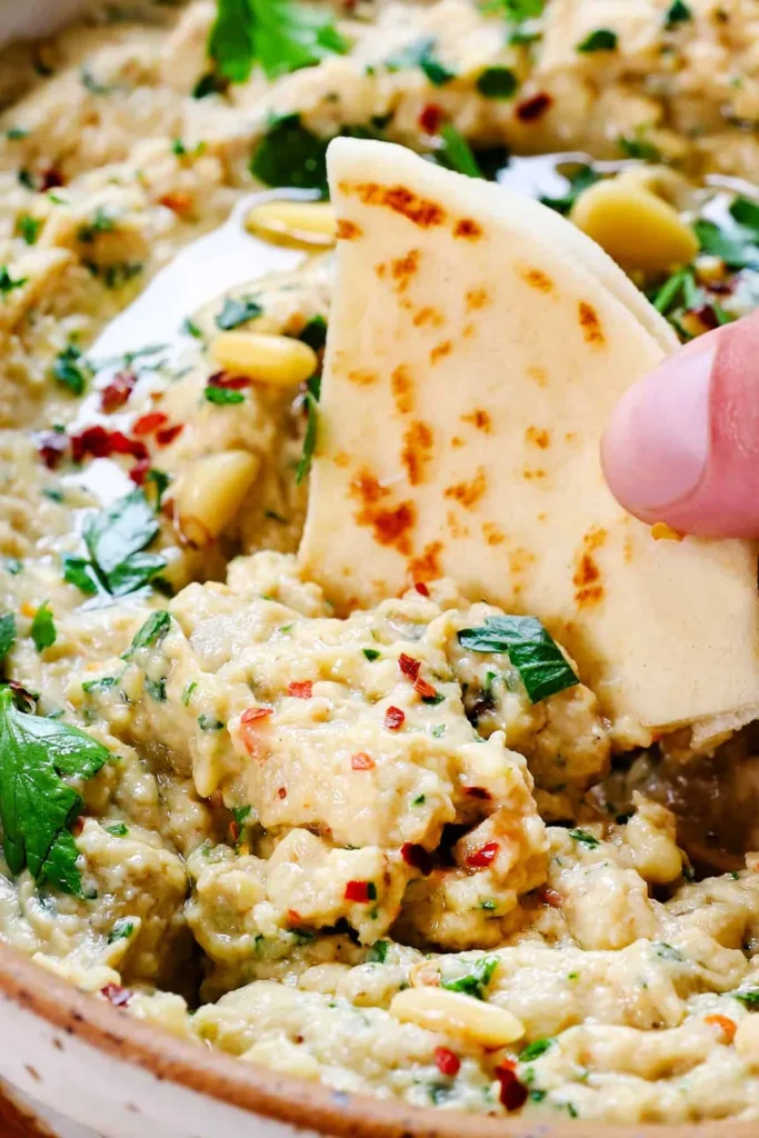 creamy baba ganoush dip with chilli flakes, and pine nuts