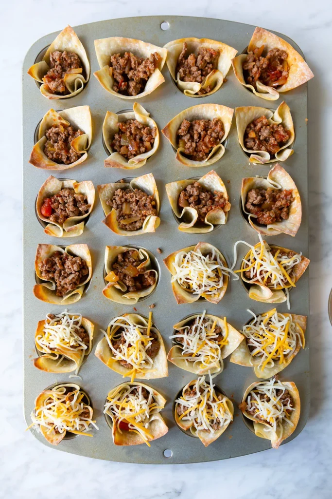 beef taco cups in a  baking tray ready for the oven