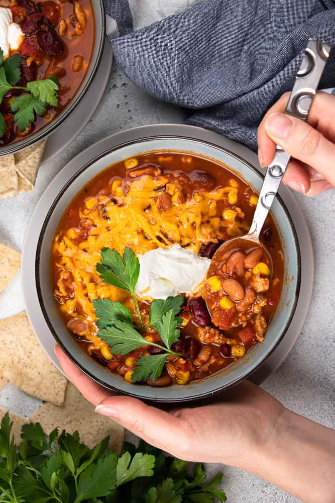 Delicious homemade instant pot turkey chili recipe topped with melted cheese and cilantro